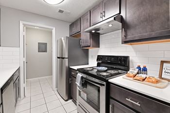 A kitchen with stainless steel appliances and a refrigerator